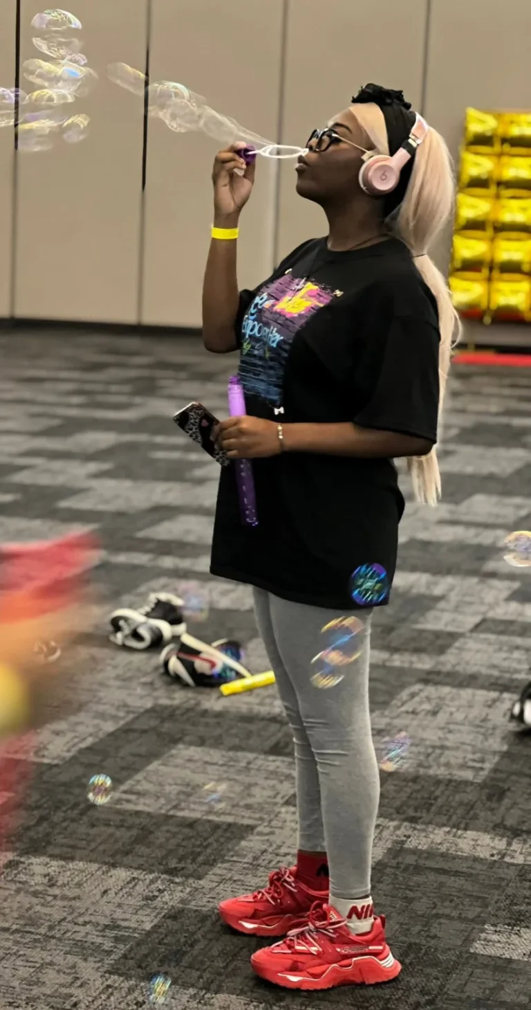 A girl blowing bubbles during an activity