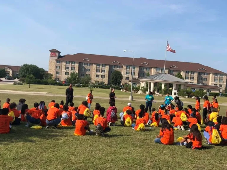 Girls gathered on a lawn during a campus visit