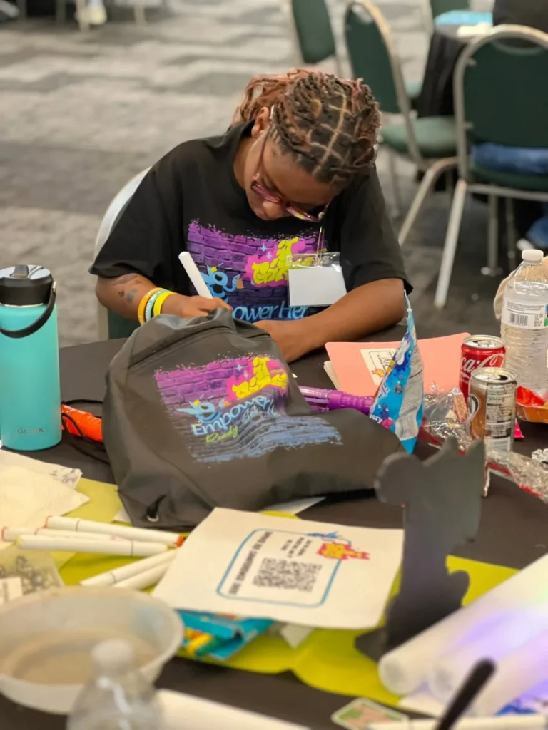 A girl decorates a tote bag at a craft station