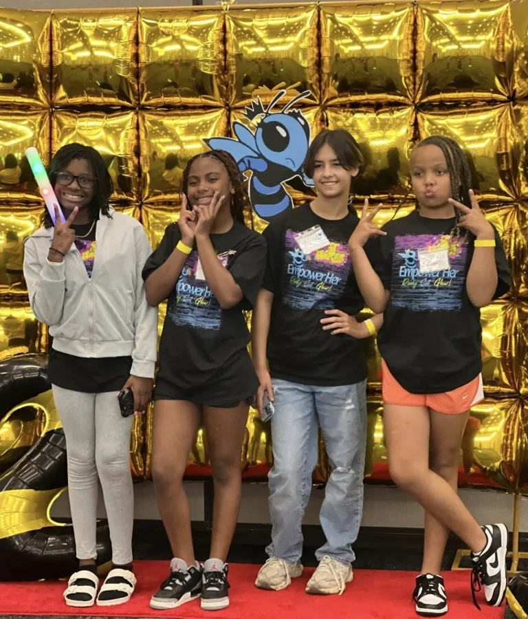 Four girls pose together at the event photo wall