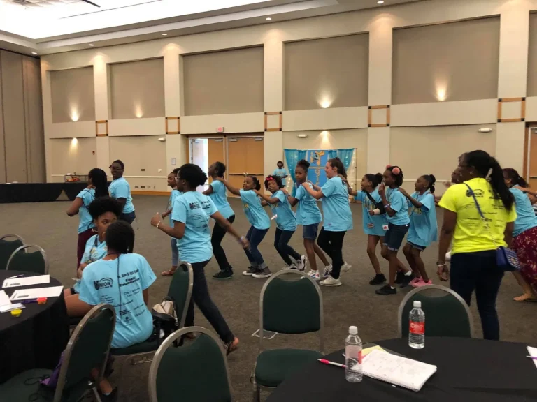 Girls moving together during an activity in a hotel ballroom