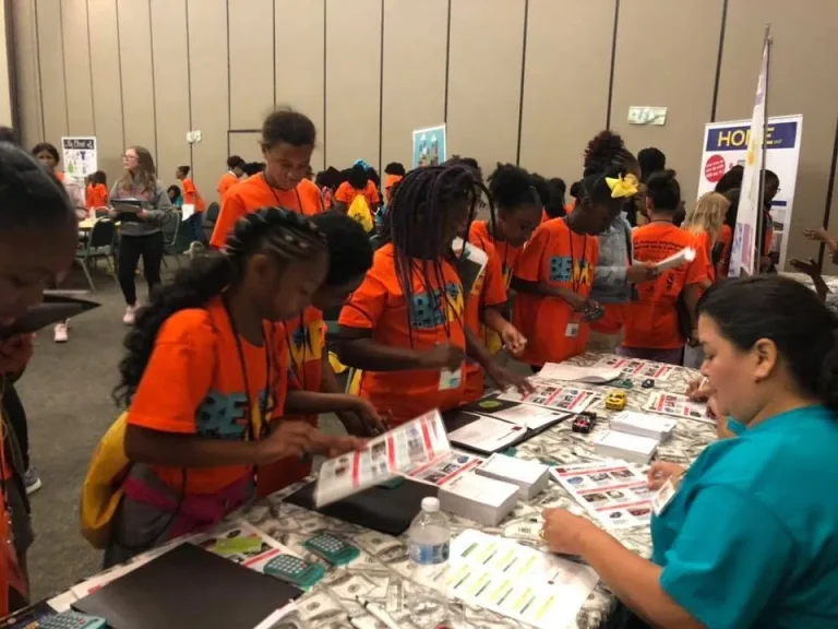 Girls looking through materials at a resource table
