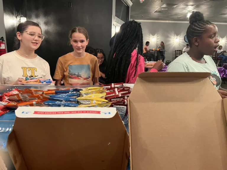 Girls at the supplies table before a session