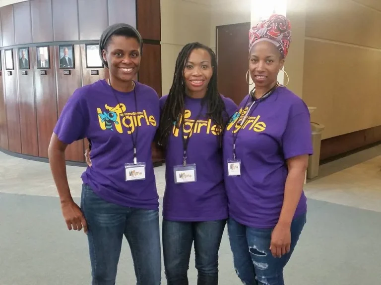 Three IT Girls volunteers at an event