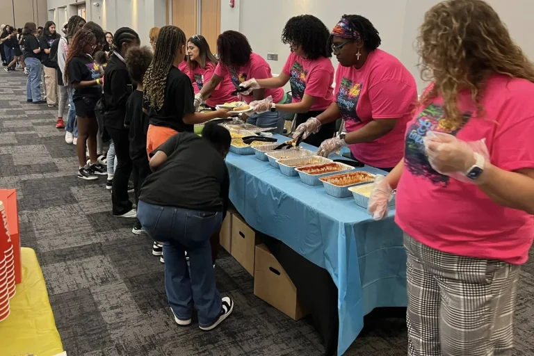 Volunteers serve a meal to the group